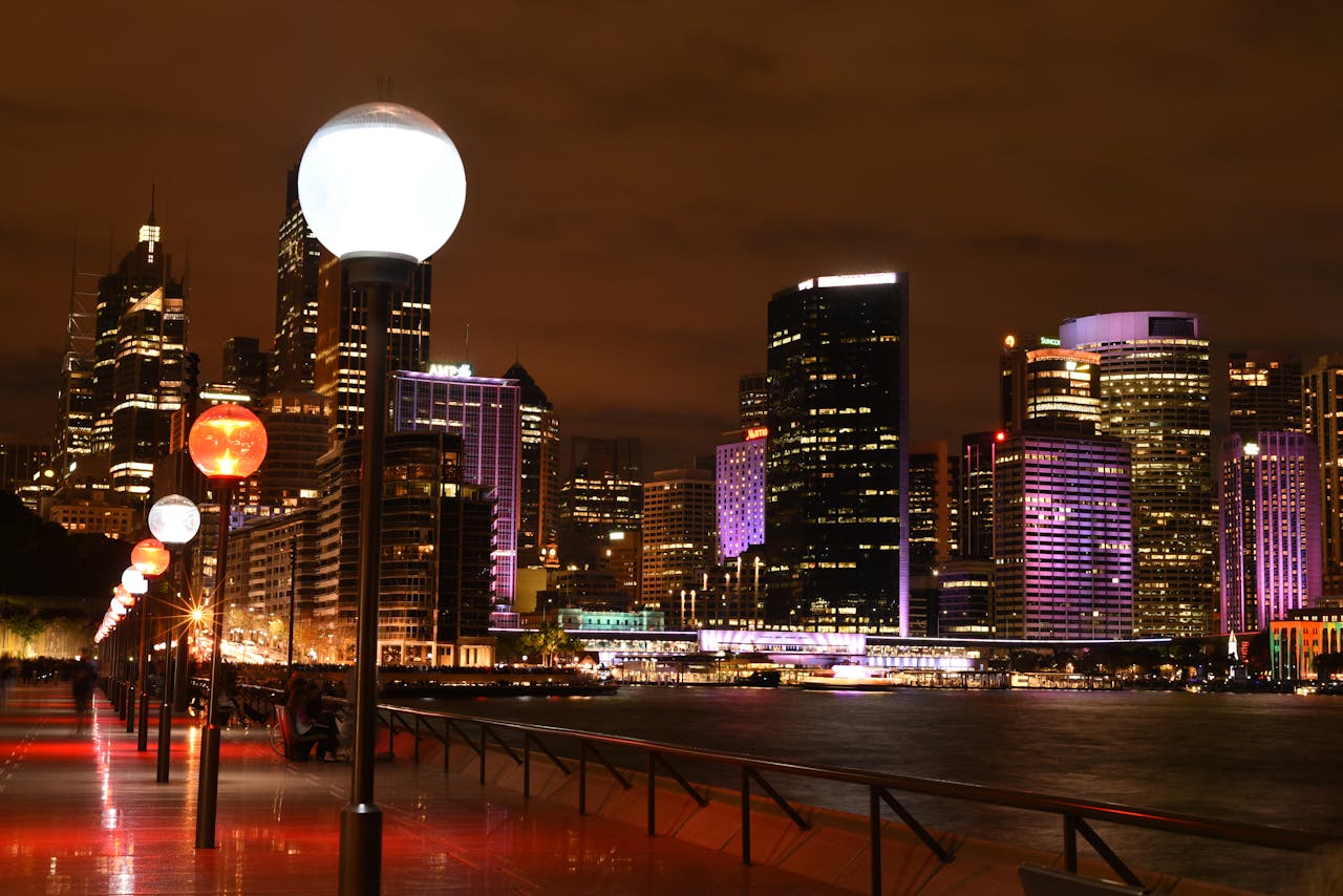 The illuminated Sydney skyline featuring skyscrapers and waterfront views at night.
